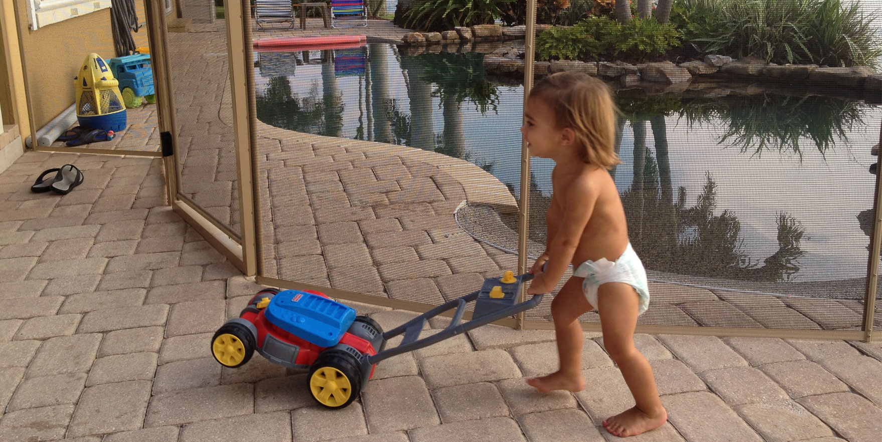 baby playing with grass mower